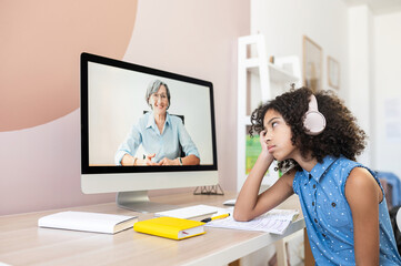 A portrait of bored African girl homeschooling with online teacher. A schoolgirl feels tired of...
