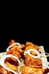 shish kebab with skewer on pita bread on a dark background