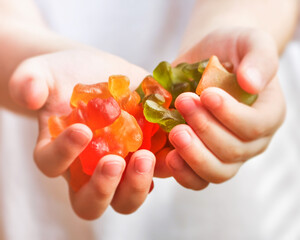 Gummies sweet food in the hands of a child