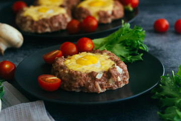 Beefsteak with egg on a plate. Delicious hot dish. The dish is decorated with cherry tomatoes and herbs. Beefsteak on a plate 