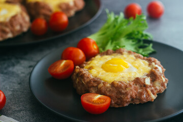 Beefsteak with egg on a plate. Delicious hot dish. The dish is decorated with cherry tomatoes and herbs. Beefsteak on a plate 