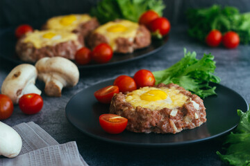 Beefsteak with egg on a plate. Delicious hot dish. The dish is decorated with cherry tomatoes and herbs. Beefsteak on a plate 