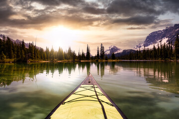 Kayaking in a glacier lake during a vibrant sunny summer morning. Sunrise Sky Art Render. Taken in Bow Lake, Banff National Park, Alberta, Canada.