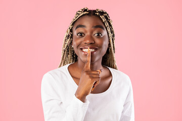 Fototapeta na wymiar Afro woman puting finger on lips, making hush sign