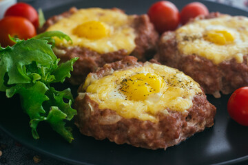 Beefsteak with egg on a plate. Delicious hot dish. The dish is decorated with cherry tomatoes and herbs. Beefsteak on a plate 