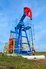 Fototapeta na wymiar The blue and red oil rig on a sunny day against a blue sky. View from below.