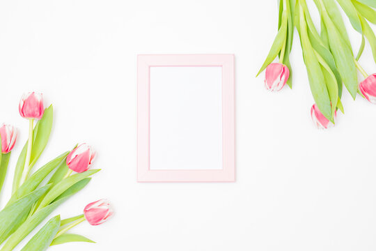 Mockup with a pink frame and pink tulips on white background