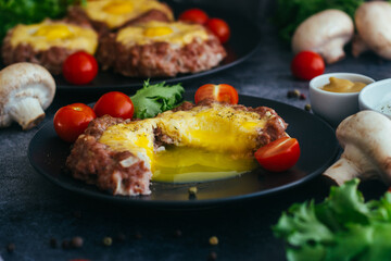 Beefsteak with egg on a plate. Delicious hot dish. The dish is decorated with cherry tomatoes and herbs. Beefsteak on a plate 