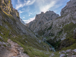 Fototapeta na wymiar The Cares river canyon along the Cares Route in the heart of Picos de Europa National Park, Spain. Narrow and impressive canyon between cliffs, bridges, caves, footpaths and rocky mountains.