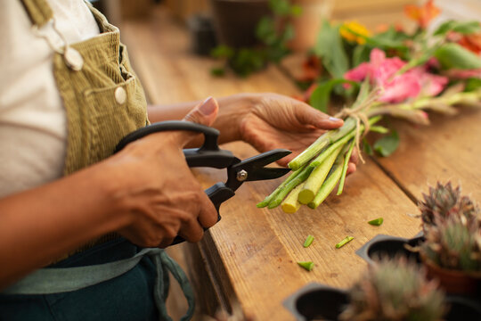 Female florist trimming flower stems with shears