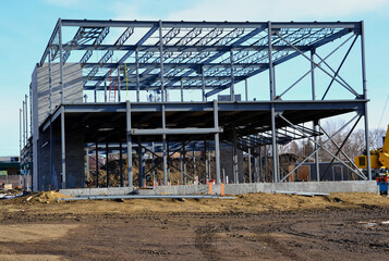 Two story steel frame commercial building under construction in urban area.