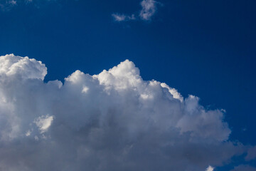 Naklejka na ściany i meble Sunny summer sky with large cumulus clouds.