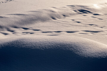 Snow background with shiny snowflakes and dark deep shadows.