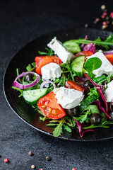 Greek salad tomato, cucumber, olives lettuce mix greens vitamins vegetable portion on the table healthy meal snack top view copy space for text food background rustic image keto or paleo diet