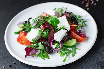 Greek salad tomato, cucumber, olives lettuce mix greens vitamins vegetable portion on the table healthy meal snack top view copy space for text food background rustic image keto or paleo diet