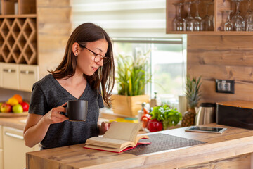 Woman drinking coffee and reading a book