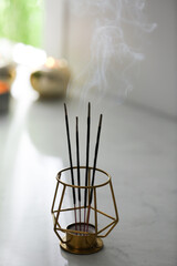 Fototapeta na wymiar Incense sticks smoldering on table in room