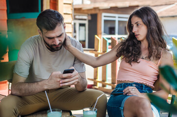 Alienation addiction. Young couple sitting in cafe and typing on their own phones