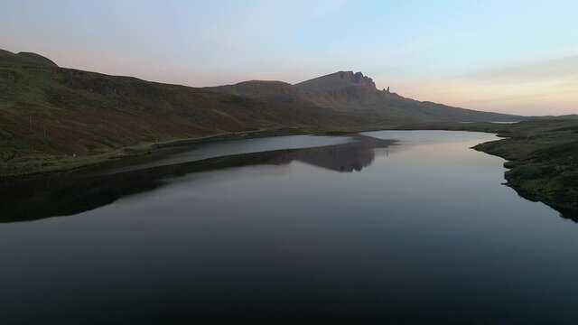 Super wide aerial shot flying near Old Man of Storr above a lake in Isle of Skye Scotland