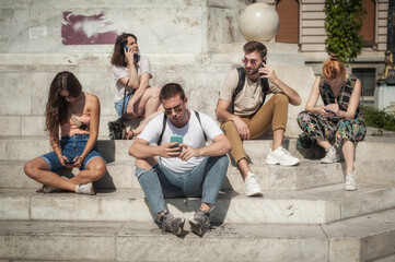 Fototapeta na wymiar Alienation addiction. Group of friends using smartphones together. Young people addiction to new technology trends. Youth, new generation internet friendship concept. Emotional isolation and depresion