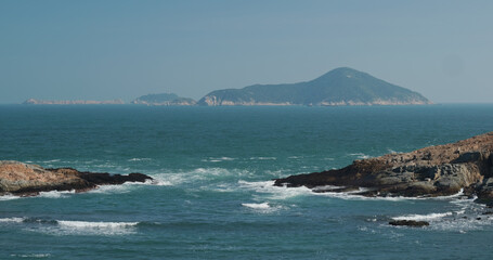 Fototapeta na wymiar Sea waves splash against rock on island