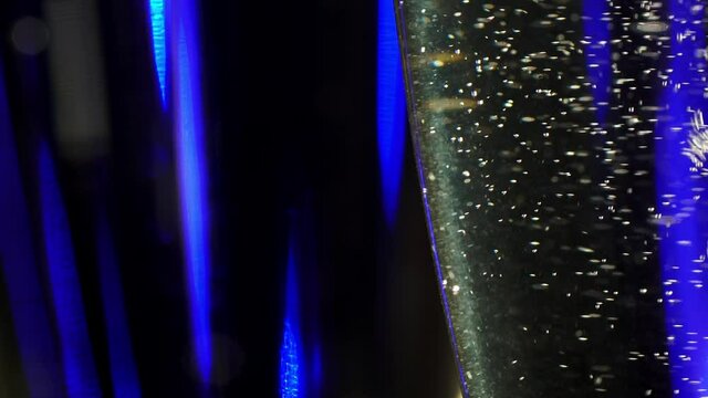 Jib footage of a transparent glass full of delicious champagne with bubbles. Sparkling wine in an elegant bocal in macro. Closeup of a delicious alcohol drink. Celebration of romantic holiday or date.
