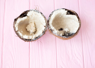 Rotten coconut on a wooden background. Spoiled products.