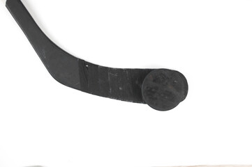 A fragment of a hockey stick and puck on a white background