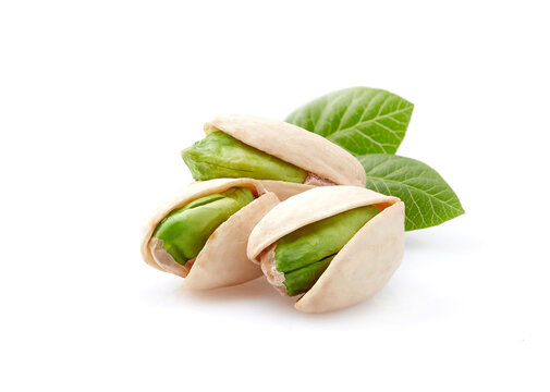 Pistachio nuts with leaves on white background