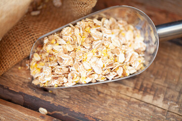 Oatmeal or oat flakes on wooden table.