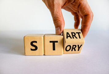 Start your story symbol. Businessman turns a wooden cube and changes the word 'story' to 'start'. Beautiful white background, copy space. Business and start your story concept.