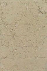 Brick wall painted faint yellow aged suburban texture vintage weathered building fascade detail with cracks and scratches