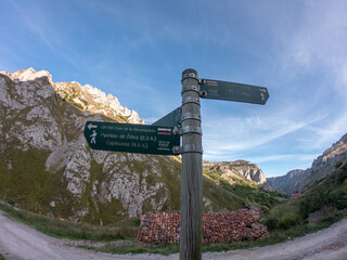 Sotres, Spain - September 3, 2020: Wooden signpost with directional signs on hiking trail in the River Duje valley near Sotres, Picos de Europa, Asturias.