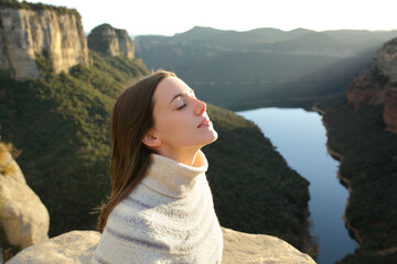 Woman breathing fresh air in a cliff in the mountain