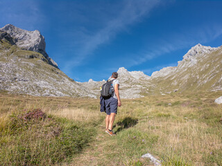 Man looking at the beautiful Monetas valley near Escamellau Peak in Sotres, Picos de Europa, Asturias, Spain.