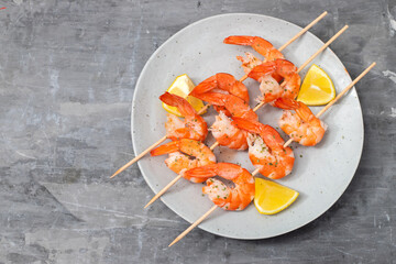 cooked shrimps on stick with lemon