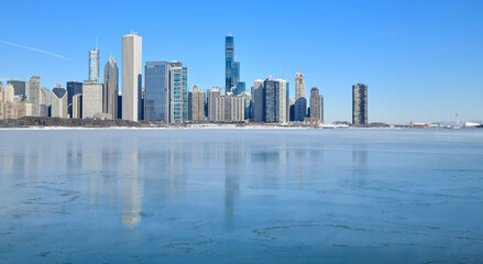 Big city skyline along frozen lakeshore in winter