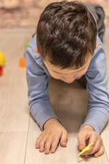 Little boy plays at home on the floor during quarantine