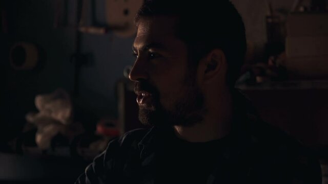 Portrait of smiling bearded man in low light