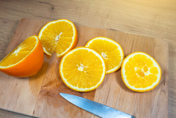 Many slices of orange lie on wooden kitchen board. Fresh citrus fruit..