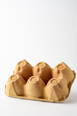 Top view of empty brown carton for six eggs, for recycling, white background, vertical, with copy space