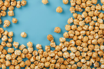 Popcorn is scattered on a blue background, in the form of a frame.
