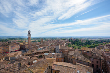 Obraz premium Panorama of Siena old town at sunrise, a medieval and Renaissance city in Tuscany, Italy, with Mangia tower and piazza del Campo, a church, old houses and palaces on a green hill