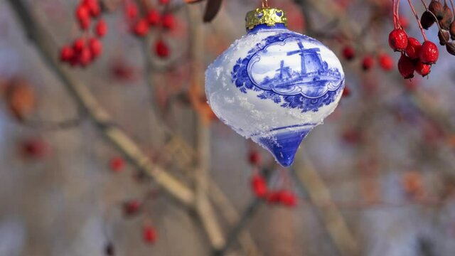 Glass Christmas toy bought in Amsterdam hangs on a branch
