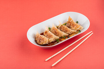 Japanese gedza dumplings with soy sauce on the pink background