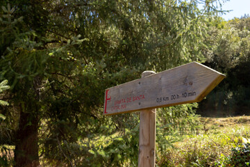 Wooden sign points to Santa Catalina Hermitage (Ermita de Santa Catalina) chapel near Santo Toribio de Liebana monastery, Potes, Picos de Europa mountains, Spain.