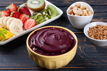 Brazilian frozen açaí in a bowl accompanied by tropical fruits. Fruit of the Amazon