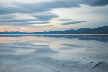 Desert landscape with wet salt field and clouds. Sunrise in Death Valley