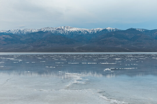 Blue Hour With Snow Capped Telescope Peak Reflecting In Wet Salt Field Of Death Valley