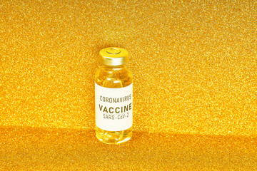 Coronavirus vaccine. Vaccine values during the acute period of the covid-19 pandemic concept. Vial on a golden background. Gold toning
